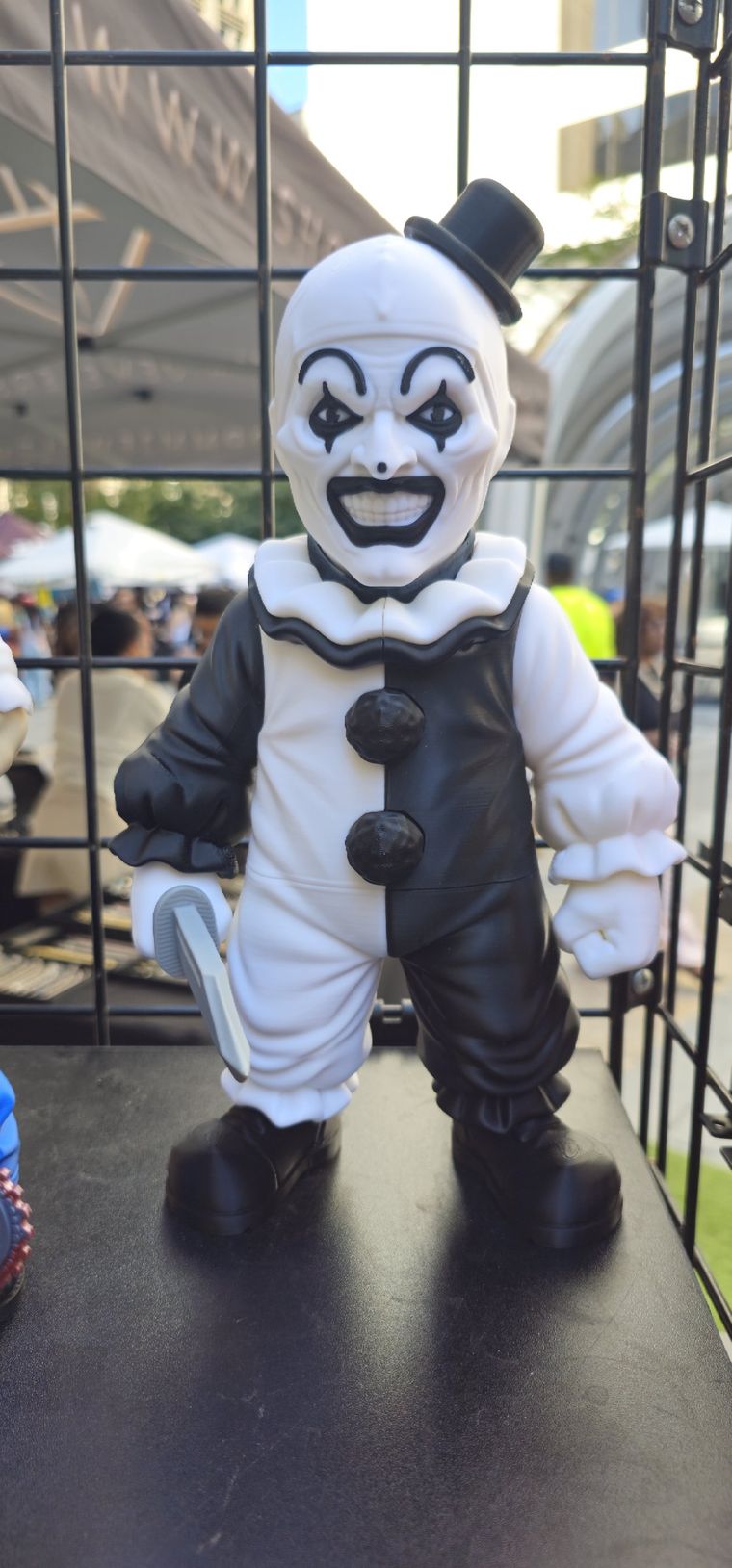 Black and white clown figure with a small top hat