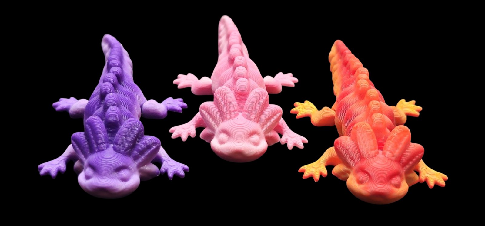 Three articulated axolotls in purple, pink and orange