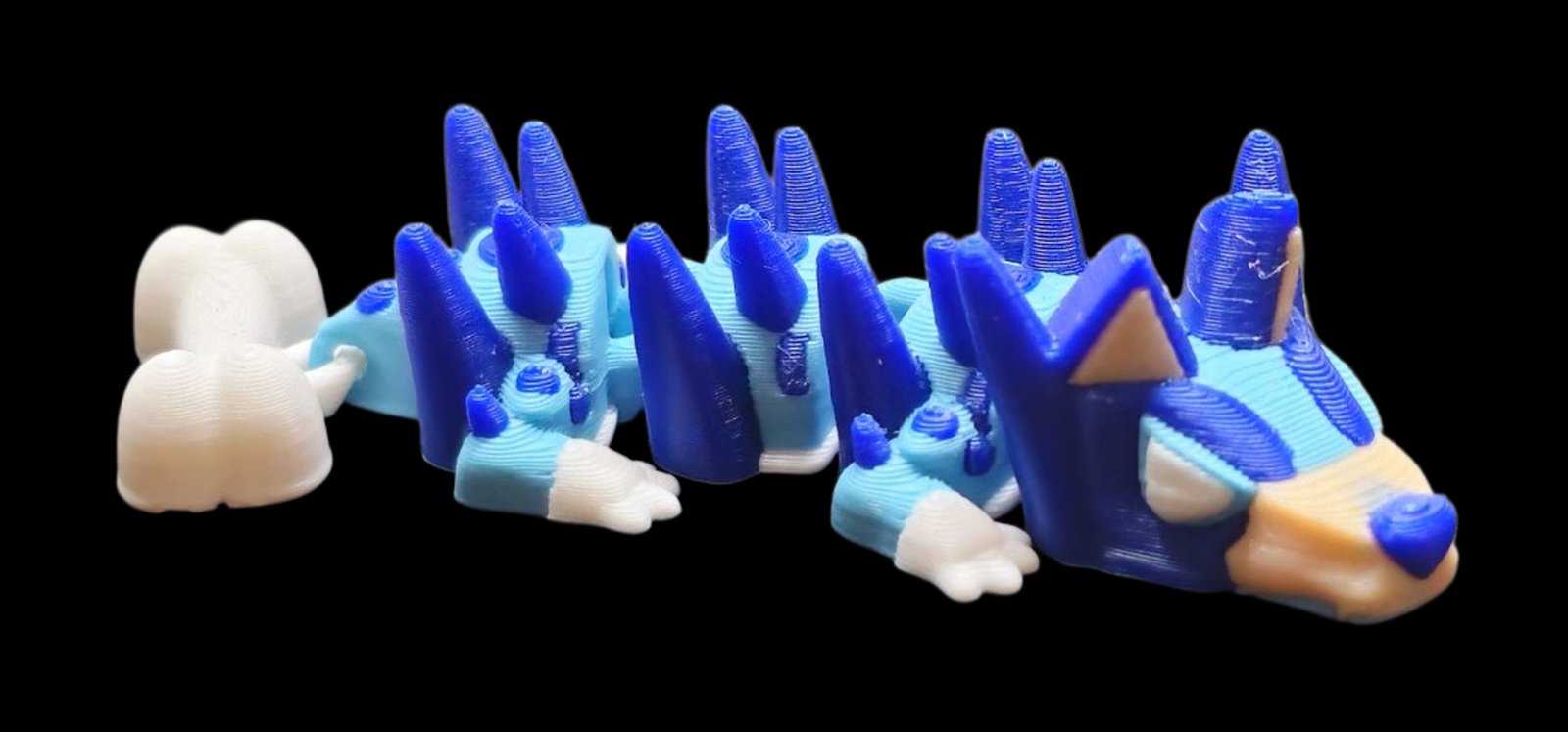 Blue articulated Bluey dragon with a dog face, pointy ears and a bone tail