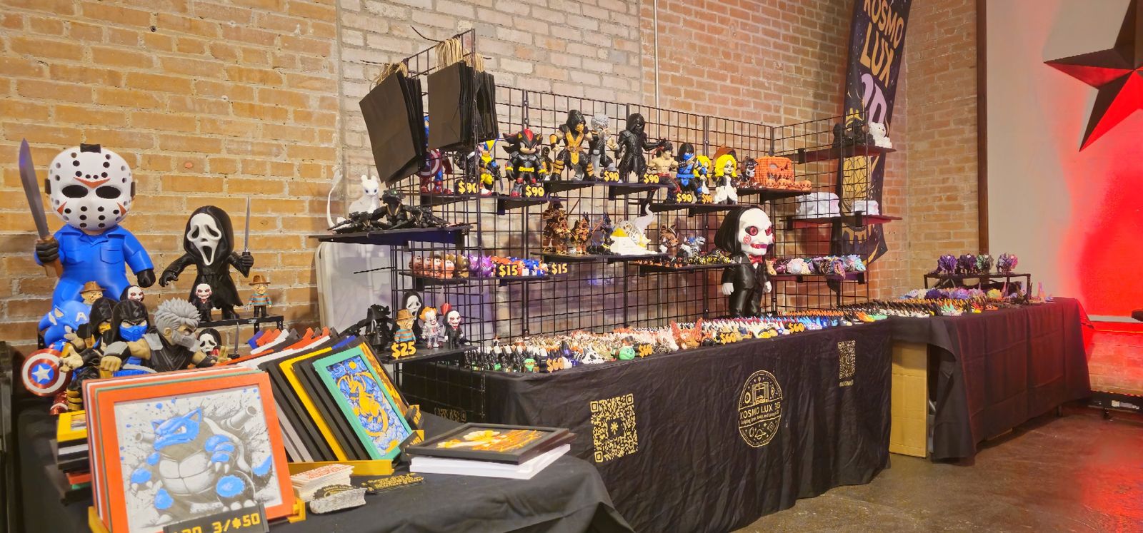 Booth corner with framed prints, masked figures and a long dragon table