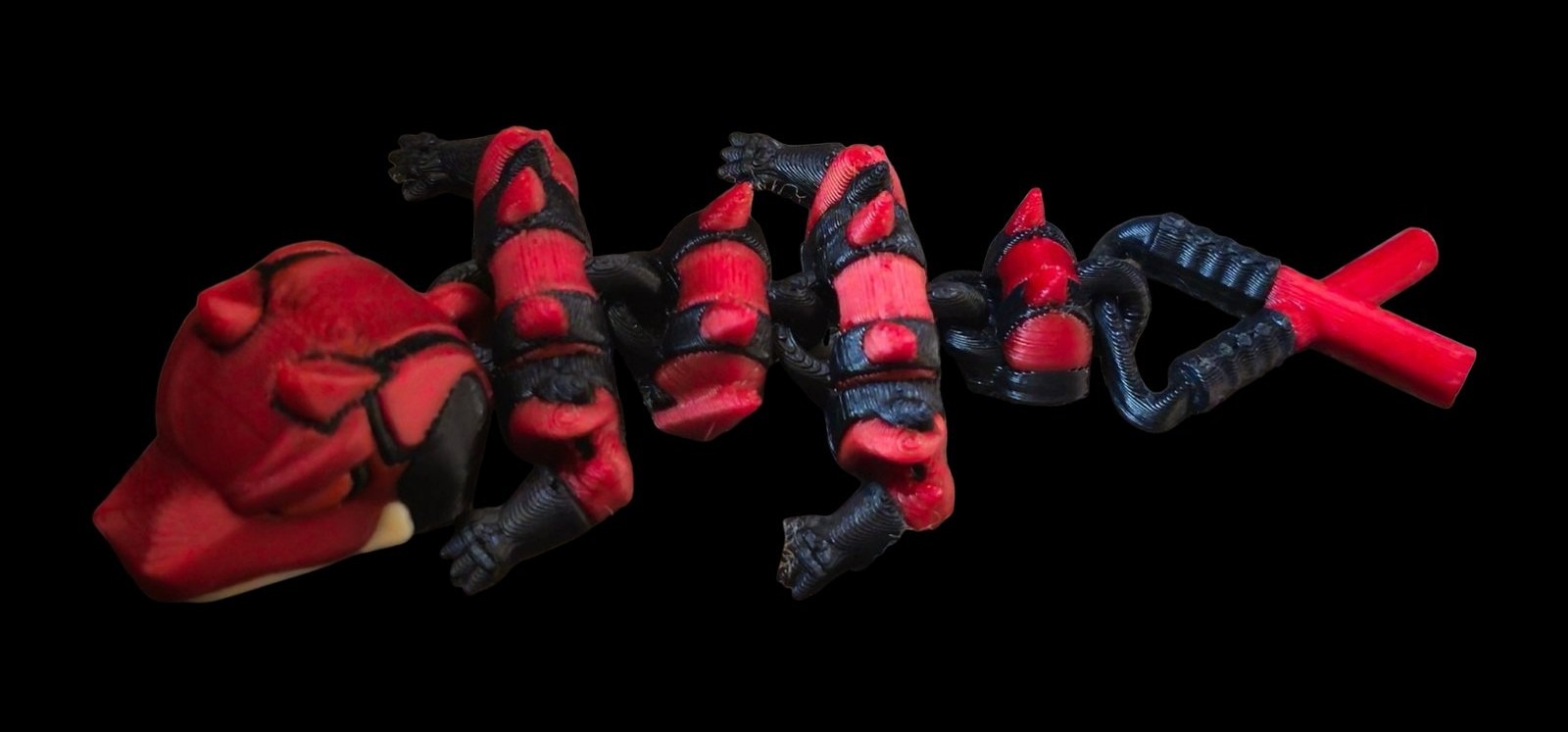 Red and black articulated Daredevil dragon with horns and billy club tail