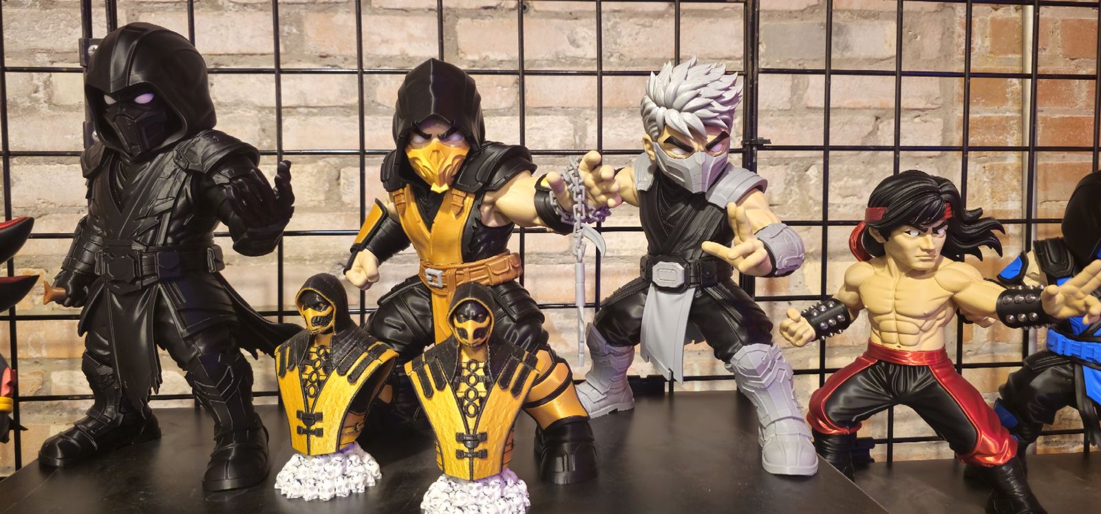Row of large 3D printed fighter figures in black, gold, grey and red