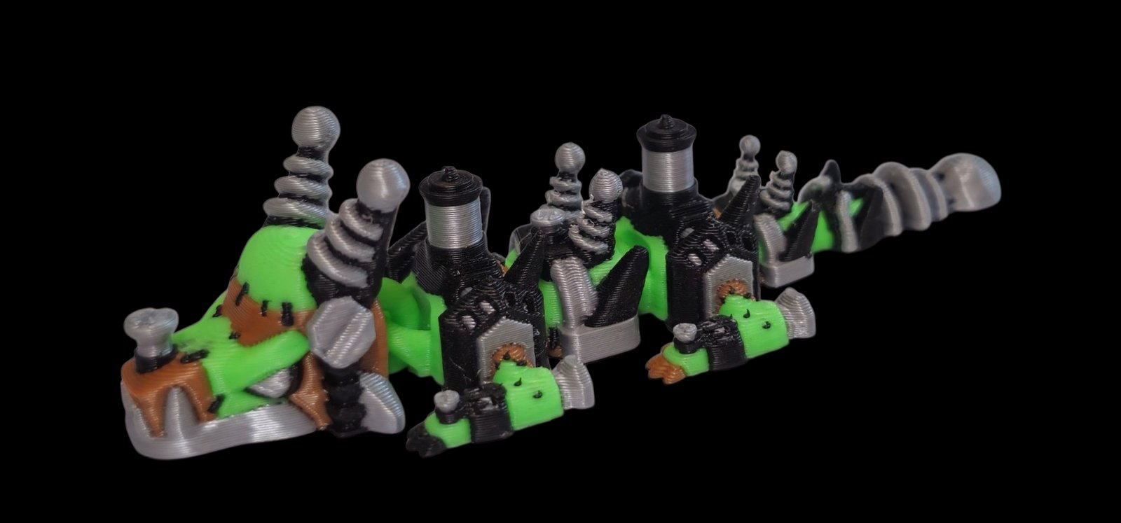 Green articulated dragon with brown stitched patches, neck bolts and little haunted houses along its back