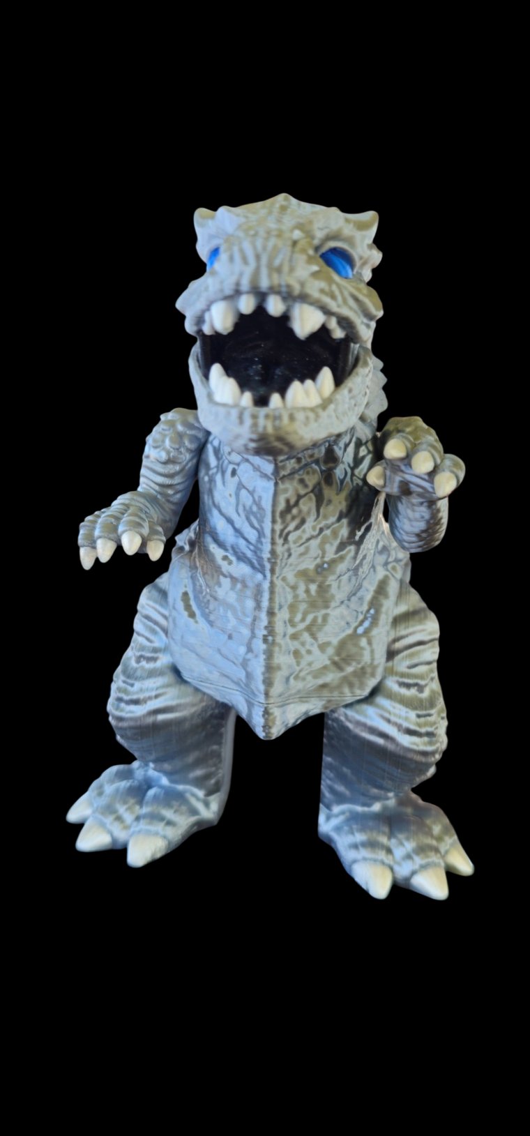 Silver and blue Godzilla figure with an open roaring mouth, white teeth and claws