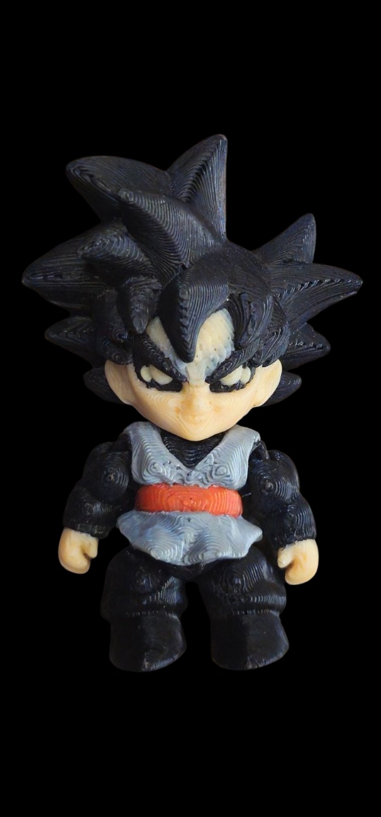 Mini Goku Black figure in a grey and black gi with a red sash