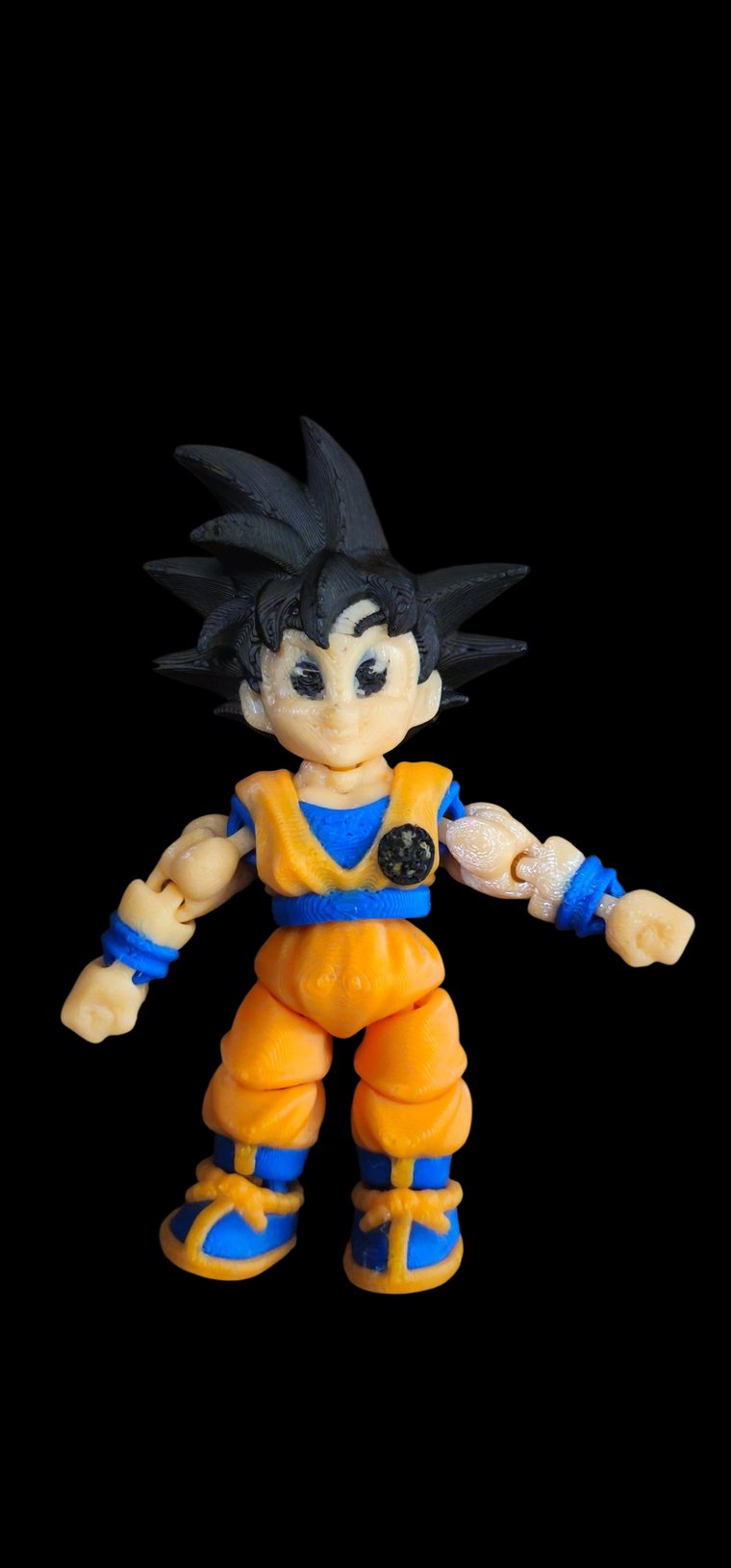 Mini Goku figure with black spiky hair and an orange gi