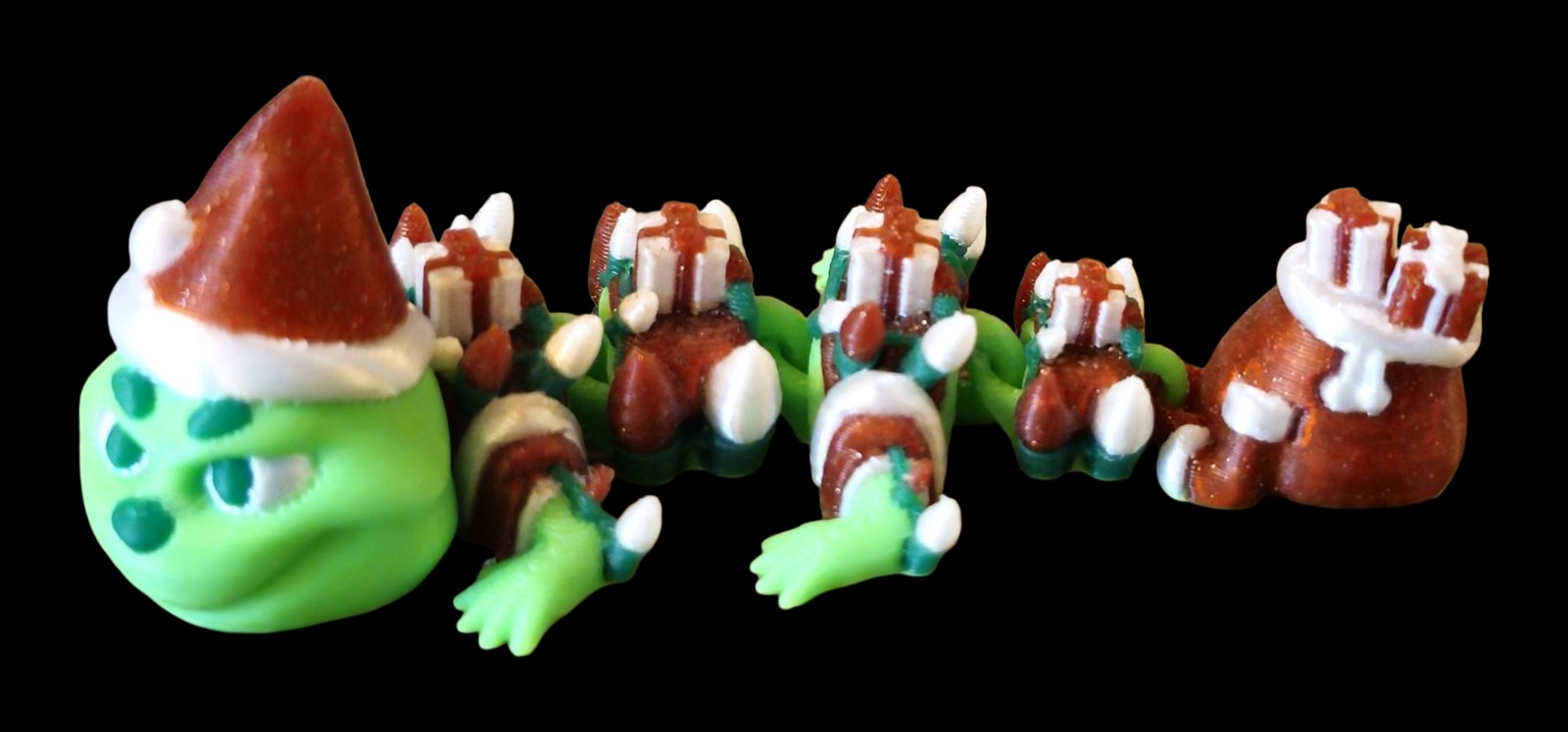 Green articulated Christmas dragon with a red Santa hat, wrapped presents along its back and a gift sack tail