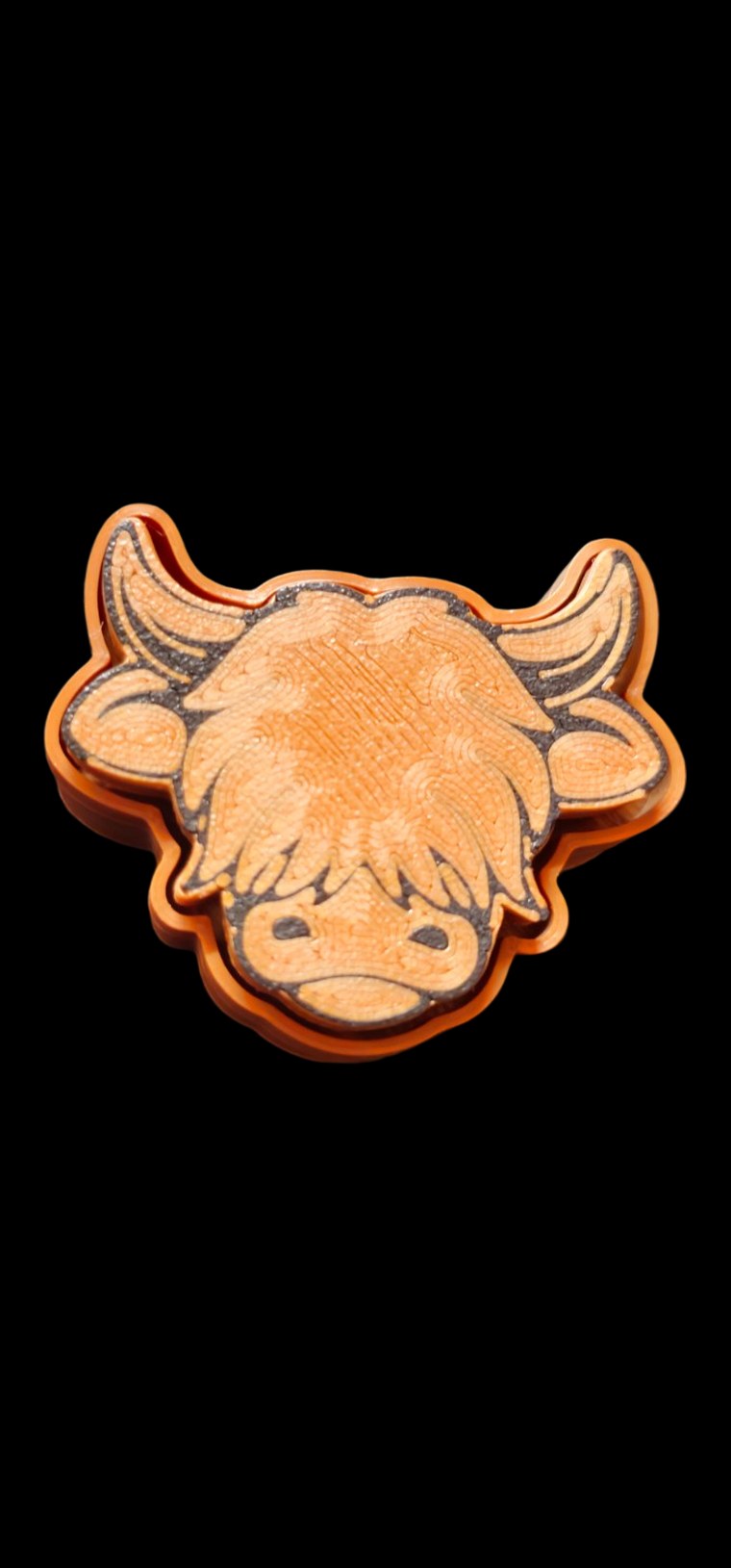 Orange layered Highland Cow fidget clicker with shaggy bangs and curved horns