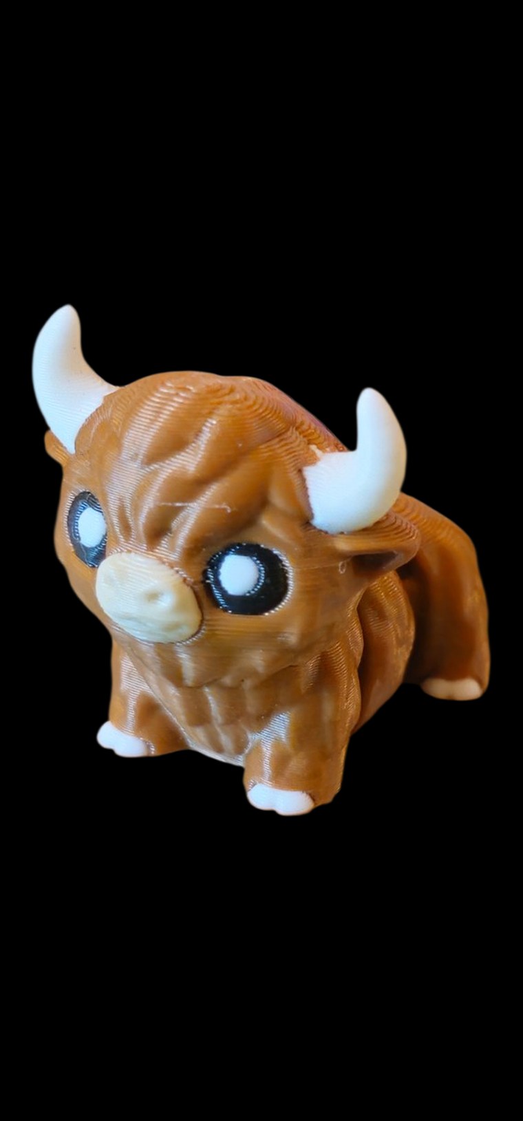 Fluffy brown Highland Cow figure with white horns and big eyes