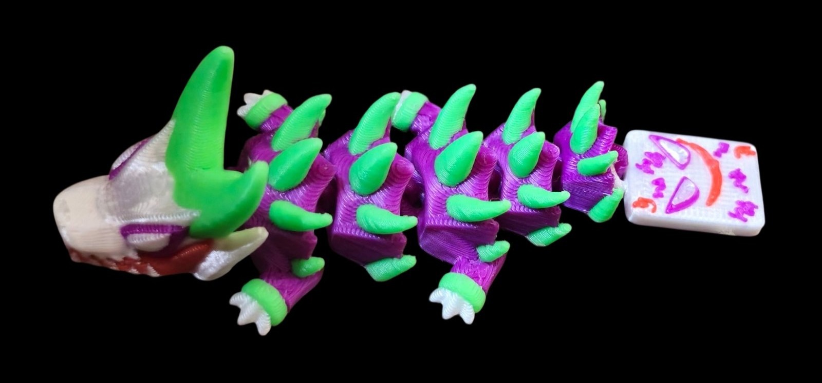 Purple and green articulated Joker dragon with a playing card tail