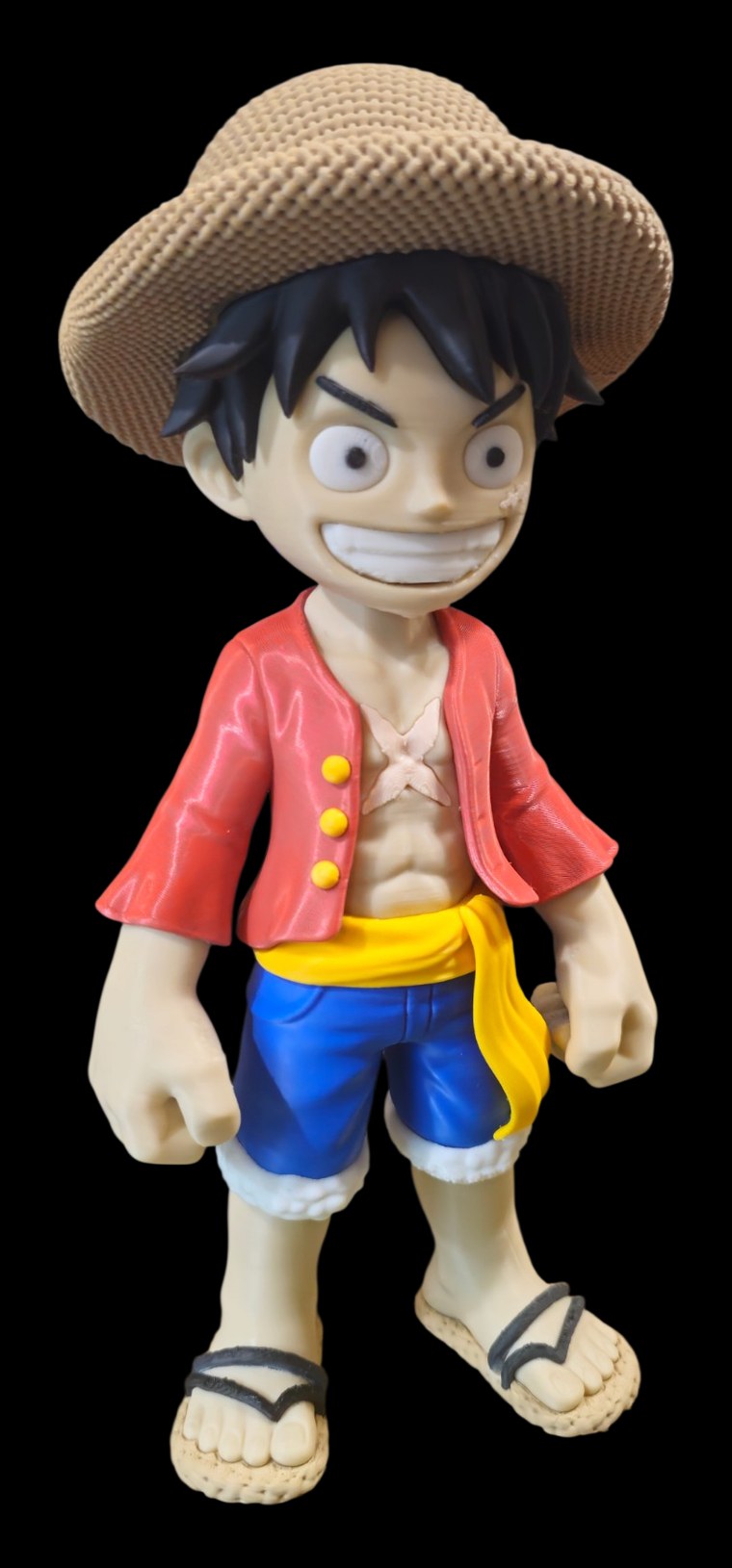 Monkey D. Luffy figure with a woven straw hat, red open shirt, yellow sash, blue shorts and sandals