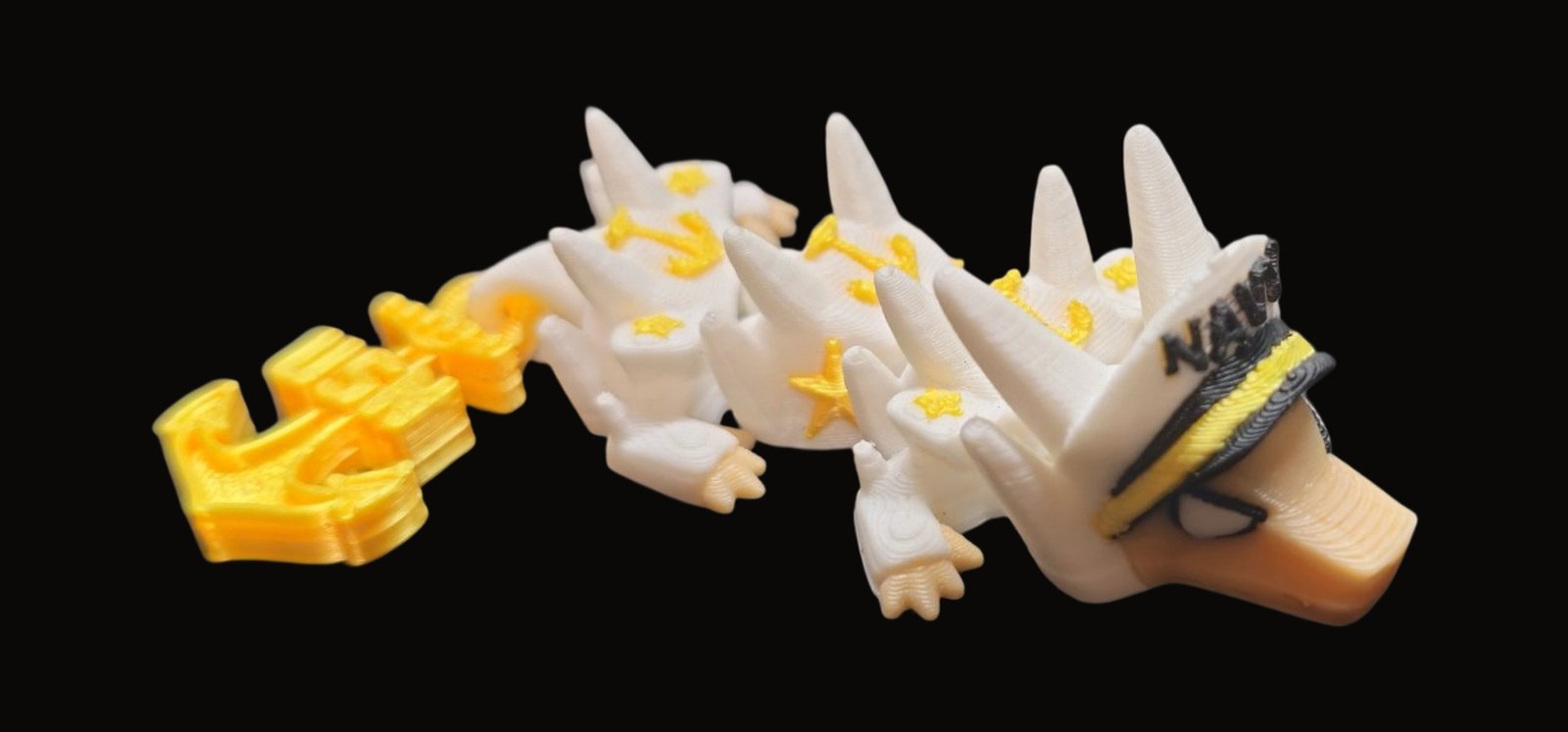 White articulated Navy dragon with gold anchors and stars, a NAVY sailor cap and an anchor tail