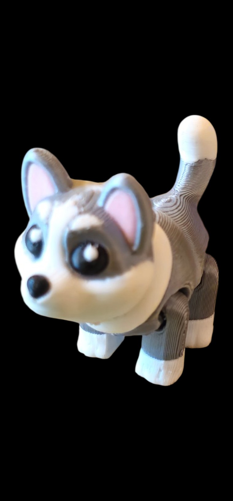 Articulated gray and white husky sled dog puppy with pink ears and a curled tail