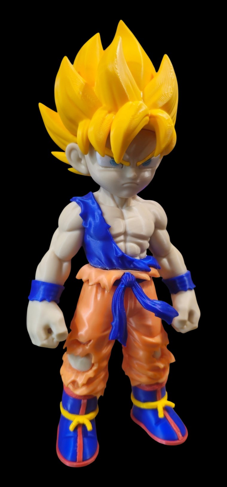 Large Super Saiyan Goku figure with spiky golden hair, torn orange gi, blue sash, wristbands and boots