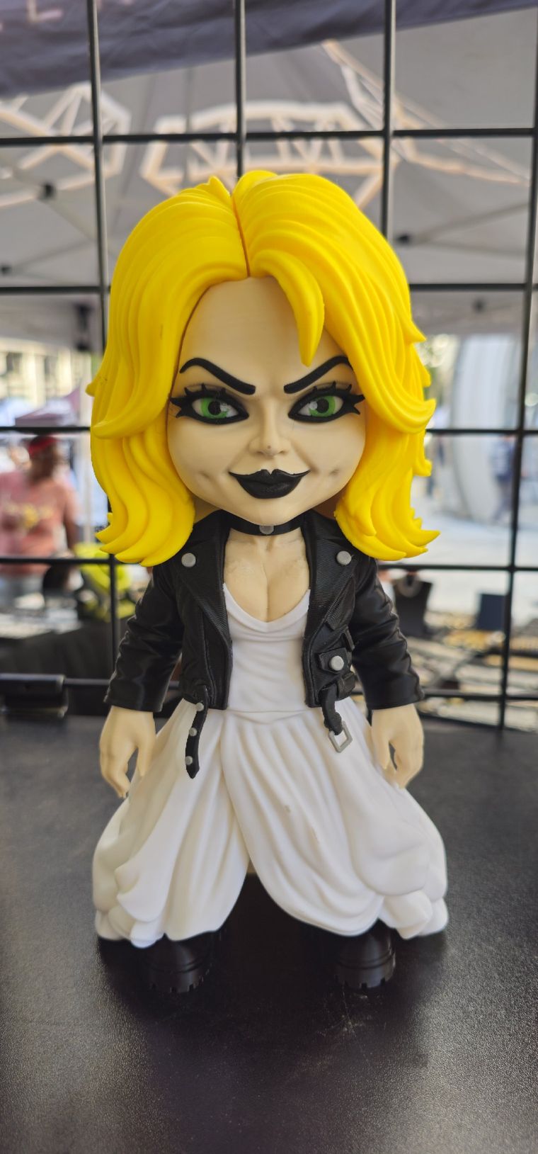 Blonde doll figure in a black leather jacket and white dress
