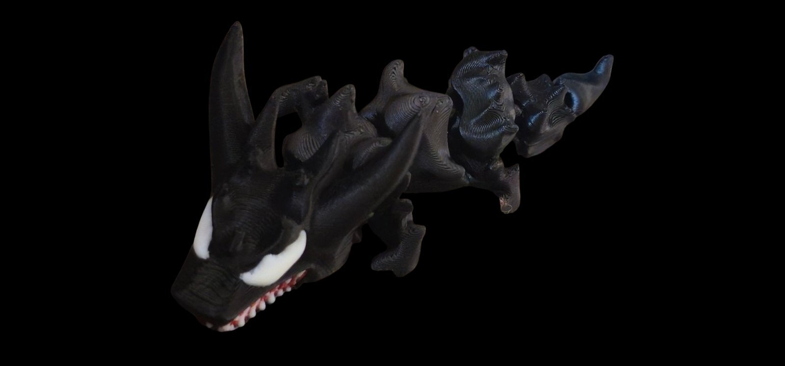 Black articulated Venom dragon with white eyes and a toothy grin